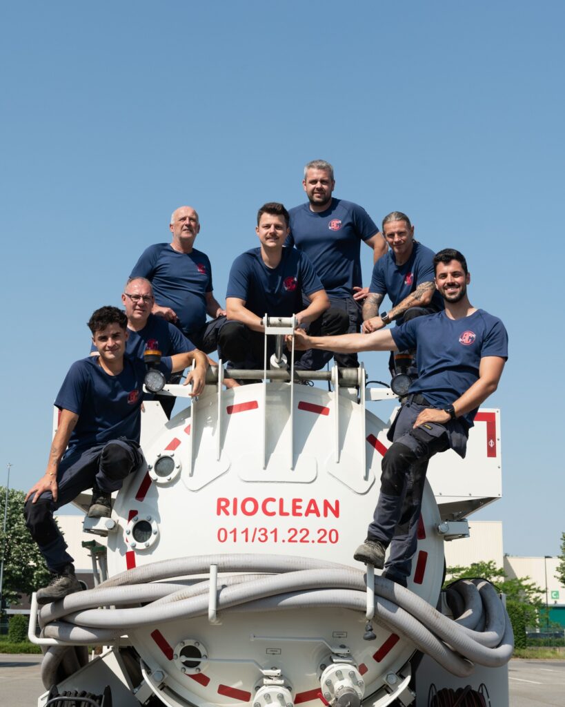 Rioclean-medewerkers op de achterkant van de tankwagen met het servicenummer
